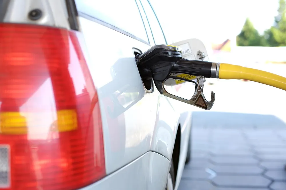 Bico de abastecimento encaixado no tanque de um carro branco